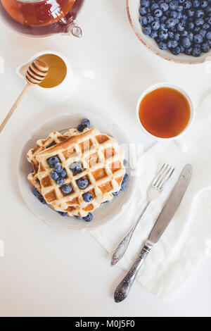 delicious breakfast of fresh waffles with blueberries and tea