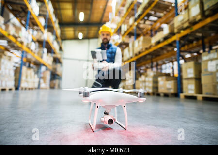 Man with drone in a warehouse. Stock Photo