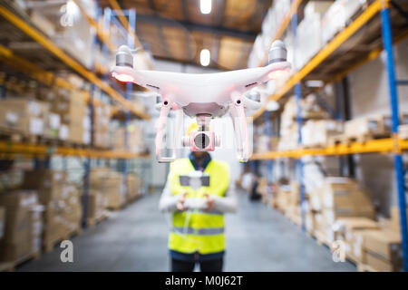 Man with drone in a warehouse. Stock Photo