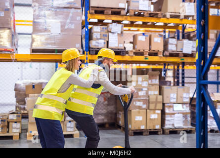 Two young workers in a warehouse. Stock Photo