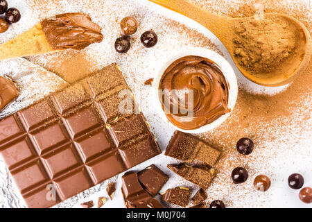 frame with different types of chocolate, powder, cream and bar on a white background Stock Photo