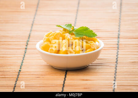 cooked sweet corn seeds in a  bowl on a wooden table. canned corn Stock Photo