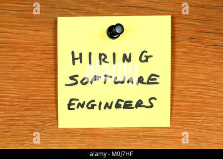 Sticky note with employment opportunity message - hiring software engineers. Bulletin board with computer jobs. Stock Photo