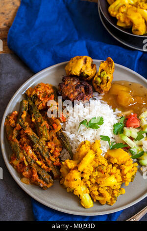 Indian meal with aloo gobi, okra curry, rice and pakoras Stock Photo