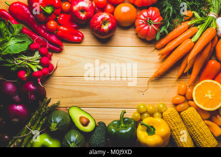 Frame full of fruits and vegetables on a wooden table seen from above with a negative space to place text or logo. Stock Photo