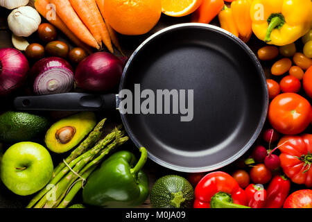 frame of different types of fruits and vegetables with a frying pan in the middle Stock Photo