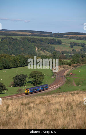 Scotrail sprinter train passes  Upper Denton (west of Haltwhistle in the Tyne Valley) with a Newcastle - Glasgow Central Via Dumfries train Stock Photo