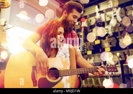 couple of musicians with guitar at music store Stock Photo