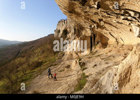 Mother and son under karst rock formations and cliffs at Veli badin, Socerga, Slovenia. Stock Photo