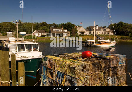 Lobster traps and a fishing boat along with a private yacht and upscale home in Whychmere Harbor, Harwich Port, Massachusetts, Cape Cod, USA Stock Photo