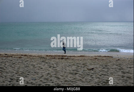 A tourist walks along Towan Beach, near Portscatho on the Roseland Peninsula, in Cornwall, Britain December 29, 2017 Stock Photo