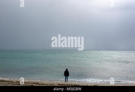 A tourist walks along Towan Beach, near Portscatho on the Roseland Peninsula, in Cornwall, Britain December 29, 2017 Stock Photo