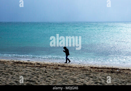 A tourist walks along Towan Beach, near Portscatho on the Roseland Peninsula, in Cornwall, Britain December 29, 2017 Stock Photo