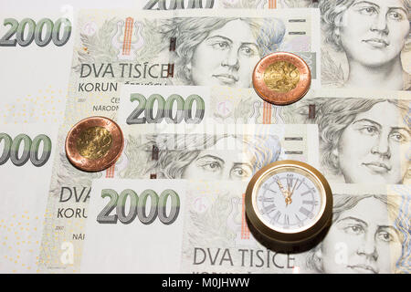 Czech banknotes like background and at the front are coins and a clock that have five to twelve time. Highest time for action. Stock Photo