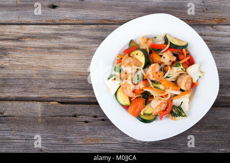 Shrimp stir fry  with vegetables over wood background Stock Photo