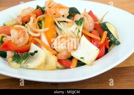 Shrimp stir fry  with vegetables over wood background Stock Photo