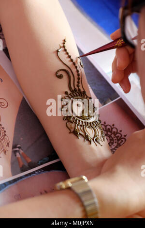 Artist drawing a traditional henna mehndi tattoo on a woman's hand Stock  Photo - Alamy