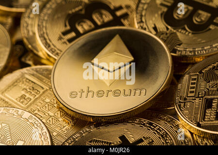 horizontal top view close up of metallic ethereum on a stack of bitcoin golden coins Stock Photo