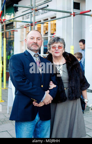 Mature couple dressed up posing for a portrait - elderly man and woman, in their Sunday best ready to dinner, in front of building. Stock Photo