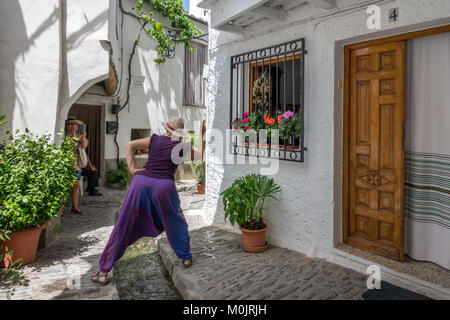 PAMPANEIRA, SPAIN- JUNE 25, 2016: Unidentified tourists enjoy taking photos on the wet streets of Pampaneira in the Alpujarra of Granada, Spain Stock Photo