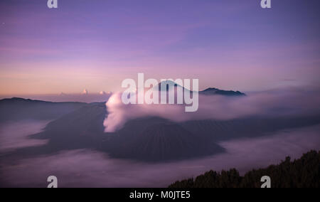 Volcanic landscape at sunrise with starry sky, smoking volcano Gunung Bromo, with Mt. Batok, Mt. Kursi, Mt. Gunung Semeru, Stock Photo