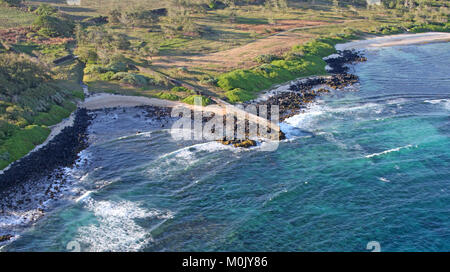 Narrow sidewalk becoming pier from field to rocky beach, view from helicopter, Savanne District, The Republic of Mauritius. Stock Photo