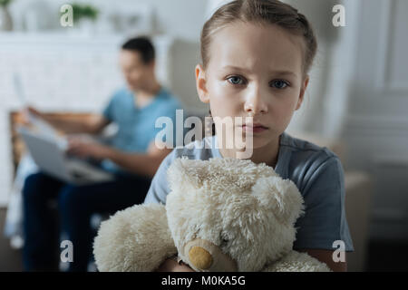 Sad little girl holding her toy Stock Photo
