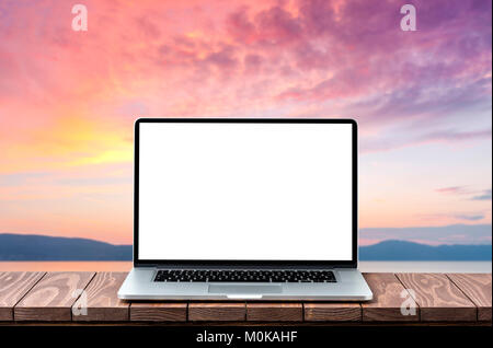 Modern laptop with empty white screen on wooden table against blurred landscape background Stock Photo