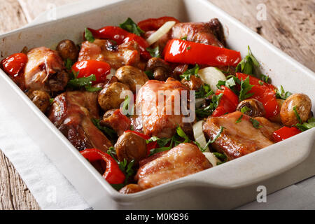 Delicious healthy rabbit baked with mushrooms and vegetables close-up in a baking dish on a table. horizontal Stock Photo