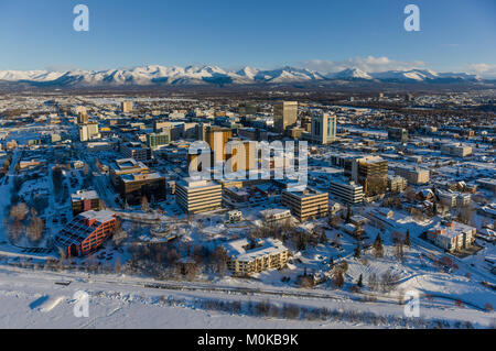 Aerial view of snow covering downtown Anchorage and the the Chugach Mountains in the distance, the Capitan Cook Hotel and Conoco Philips buildings ... Stock Photo