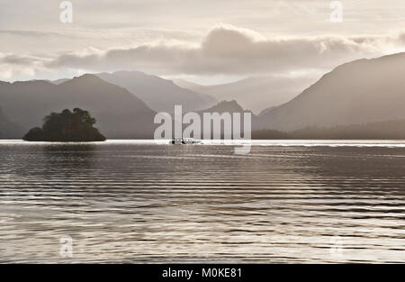 A Winter afternoon in the Lake District National Park. A pleasure cruise boat crosses Derwent Water near Keswick, Cumbria, UK Stock Photo
