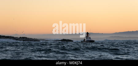 Boating at sunset in Atlantic ocean, South Africa Stock Photo