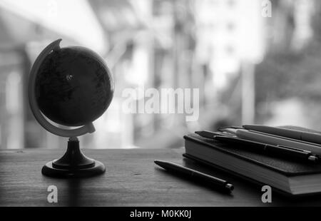 A pen on the desk with small globe Stock Photo