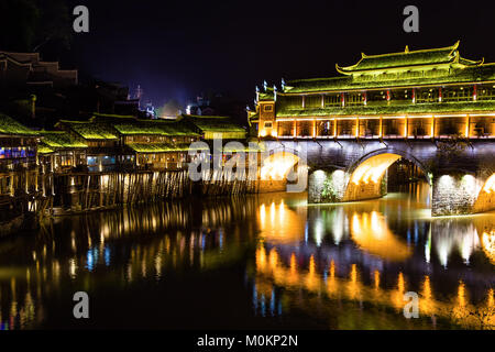 Hong Bridge at night in Fenghuang Ancient town, Hunan province, China. This ancient town was added to the UNESCO World Heritage Tentative List in the  Stock Photo