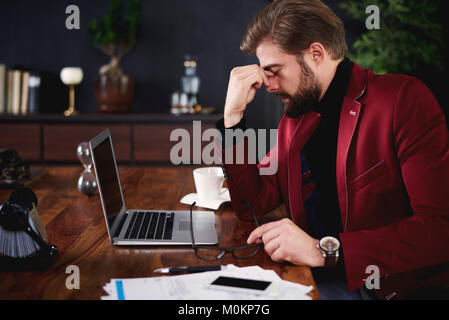 Exhausted businessman at his office Stock Photo