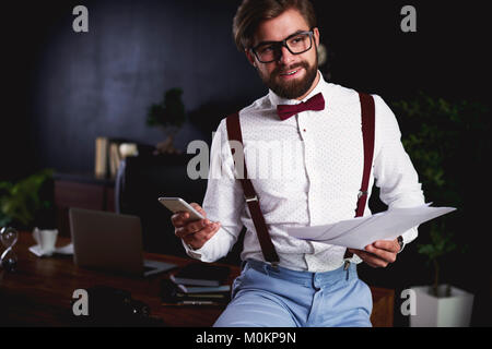 Man with financial documents and mobilephone Stock Photo