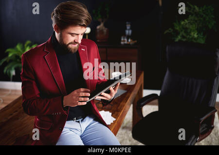 Focused man working with digital tablet at home office Stock Photo