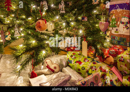 Christmas tree with decorations, lights and Christmas presents. Stock Photo
