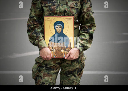 Soldier holding orthodox religious icon of saint Anastasia Stock Photo