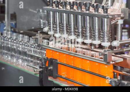 orange juice bottle on factory line machine in the factory, orange bottles transfer on conveyor belt system Stock Photo