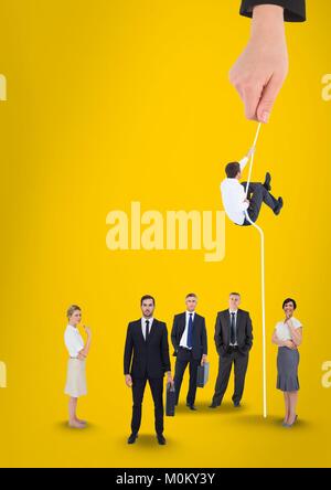 Hand choosing a man with a rope on a yellow background with business people Stock Photo