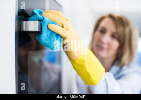 Close Up Of Woman Cleaning Oven In Kitchen Stock Photo