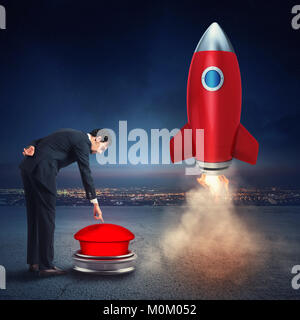 Businessman launches rocket pushing a red button. 3D Rendering Stock Photo