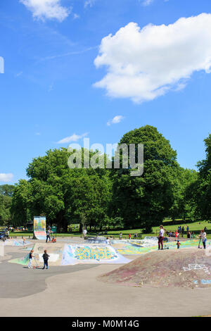 Children and adults use St George skatepark in Bristol on a sunny summer day. Stock Photo