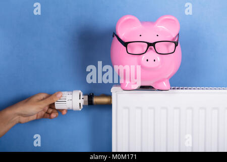 Person Hand Adjusting Temperature On Thermostat To Save Money On Energy Bill Stock Photo