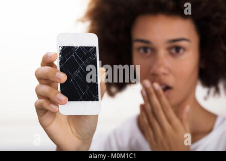 Close-up Of A Young Woman Holding Broken Mobile Phone Stock Photo