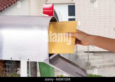 Close-up Of A Person's Hand Removing Letter From Silver Mailbox Stock Photo