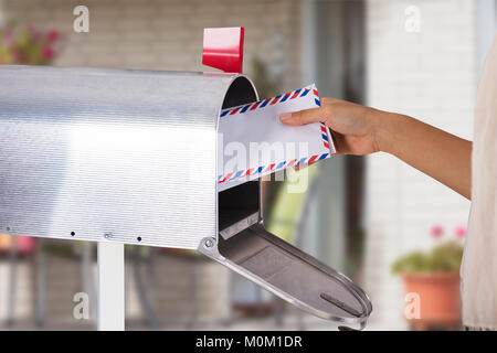 Close-up Of A Person's Hand Removing Letter From Silver Mailbox Stock Photo