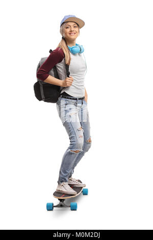 Full length portrait of a female skater with a backpack riding a longboard isolated on white background Stock Photo