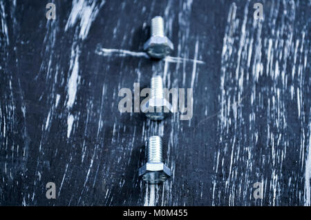 Nuts for repairs lying on a wooden table. Stock Photo